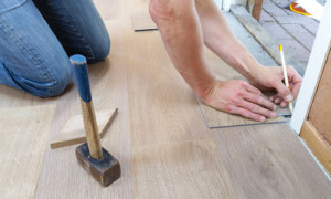 Flooring contractor installs a light hardwood